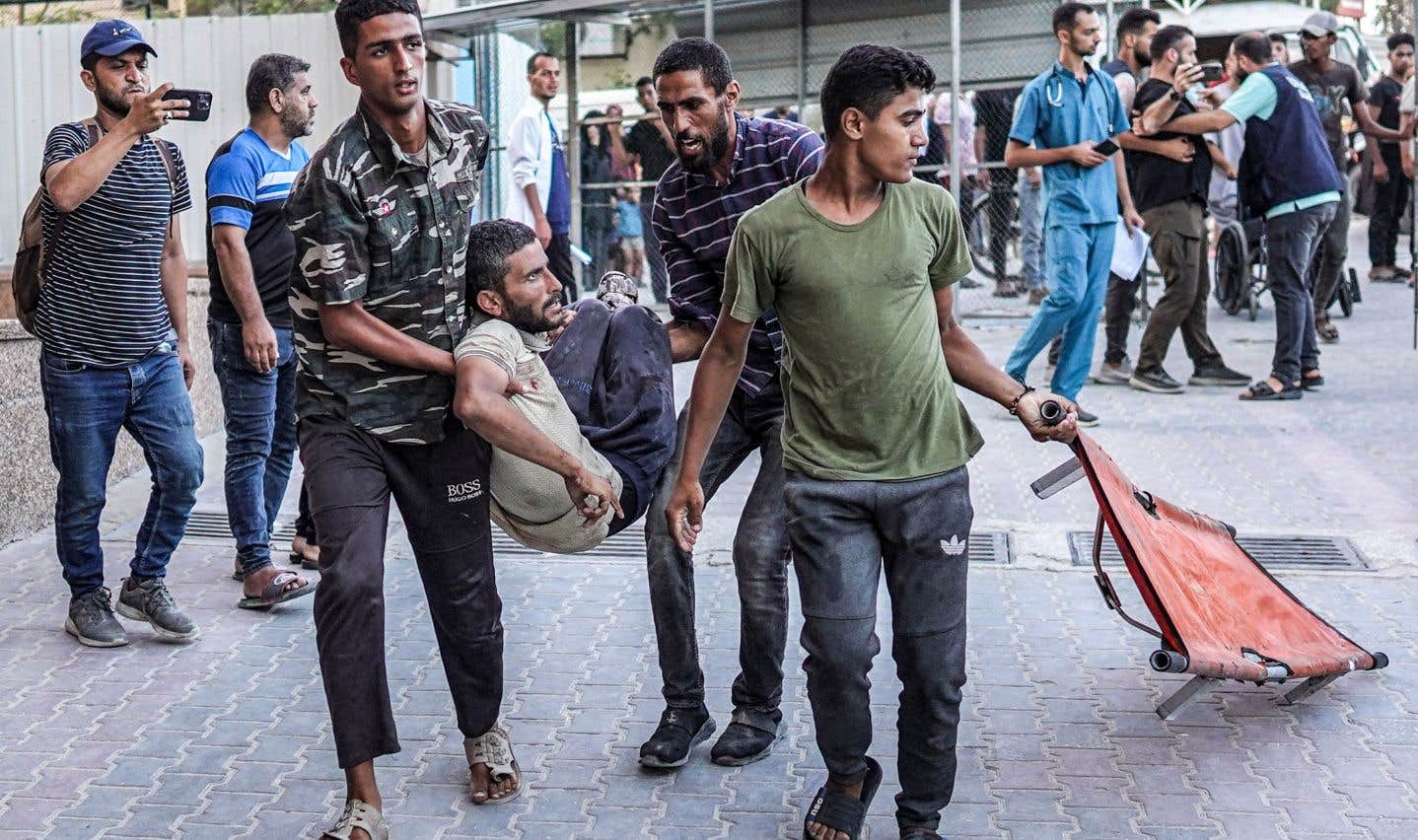 Des personnes transportent un homme blessé par les bombardements israéliens alors qu’elles arrivent devant le complexe médical Nasser à Khan Yunis,  le 5 juillet 2024. Photo by Bashar TALEB / AFP)