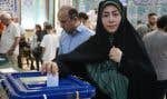 Une femme dépose son bulletin de vote dans l’urne dans un bureau de Téhéran.